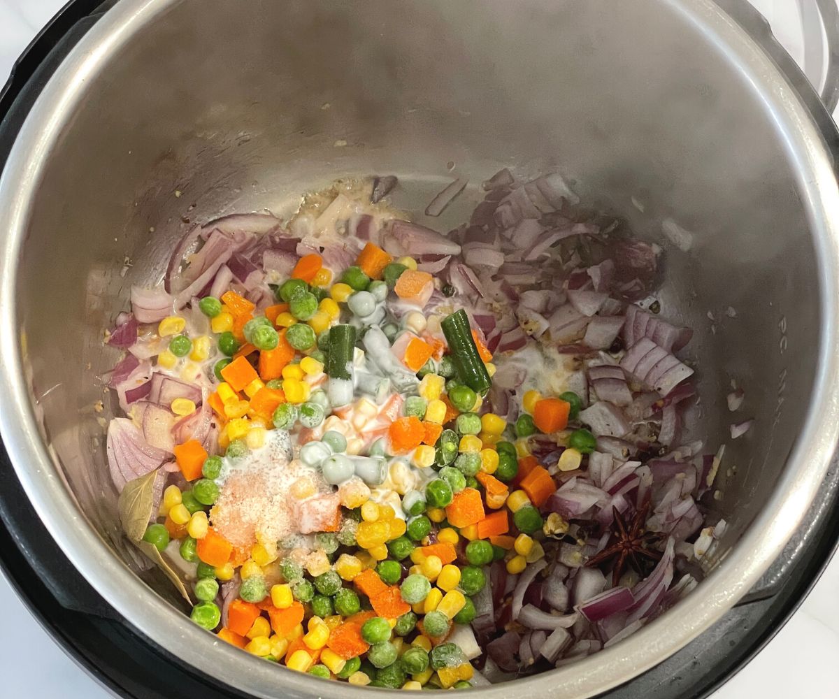 An instant pot is with vegetable pulao mixture.