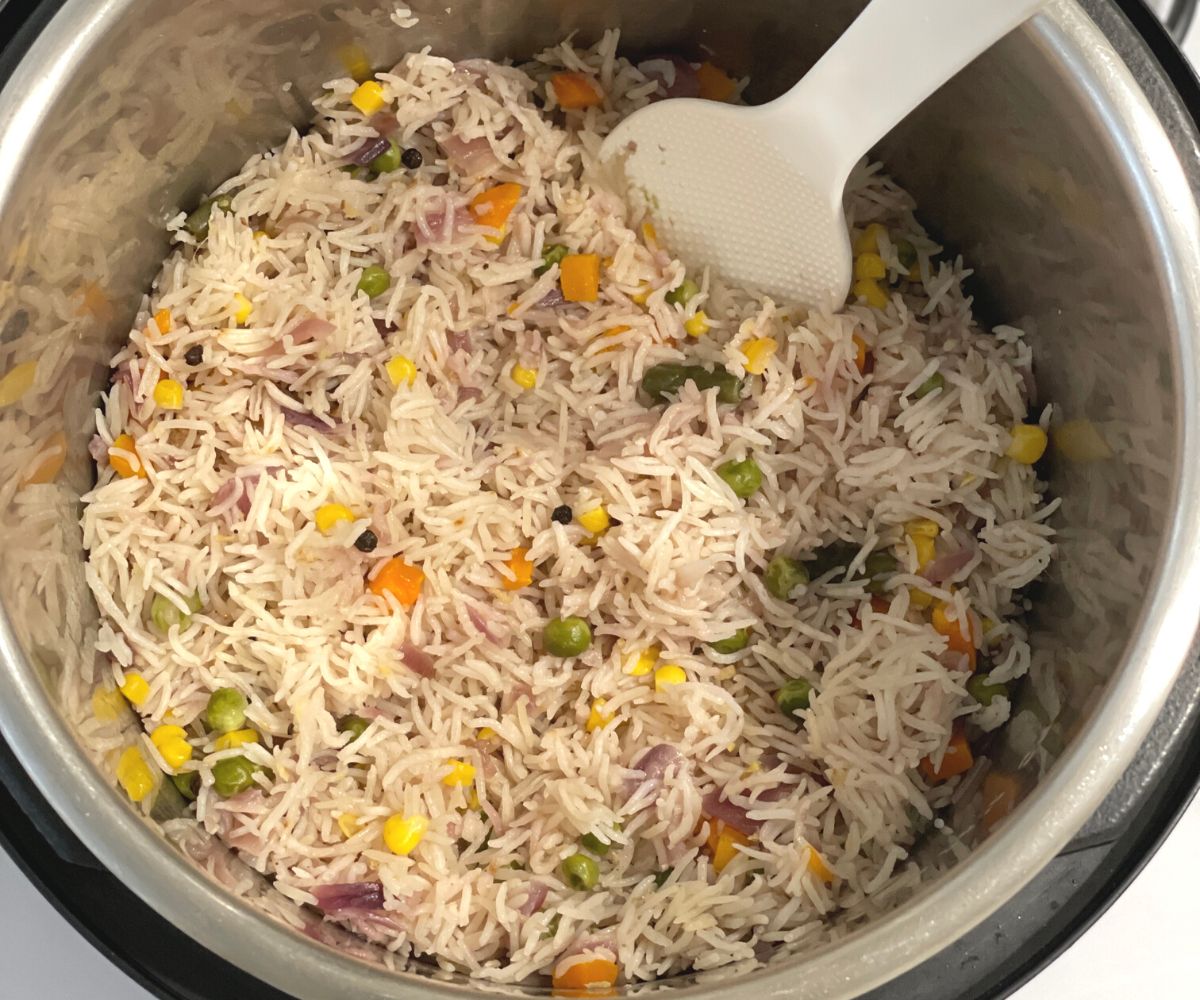 An instant pot is with vegetable pulao.