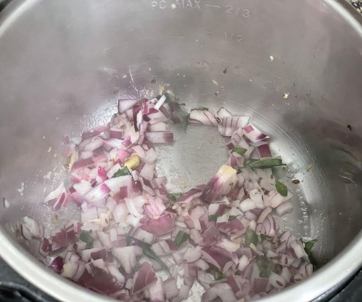 A pot is with spices and onions for khichdi.
