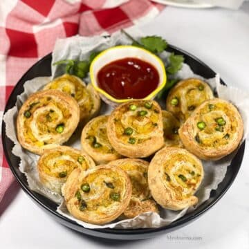 A plate is filled with air fried samosa pinwheels.
