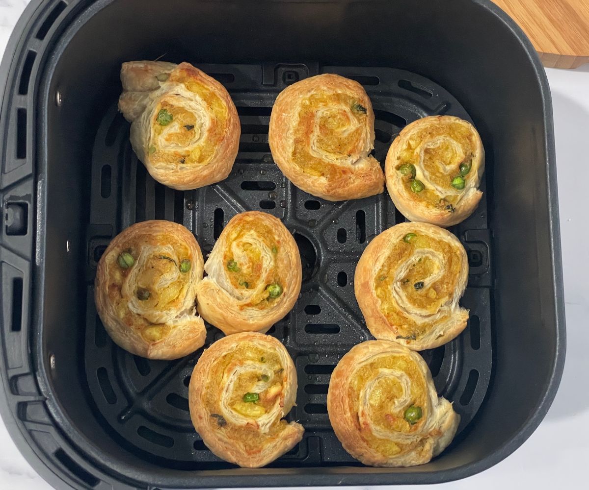 The air fryer basket is with air fried samosa pinwheels.