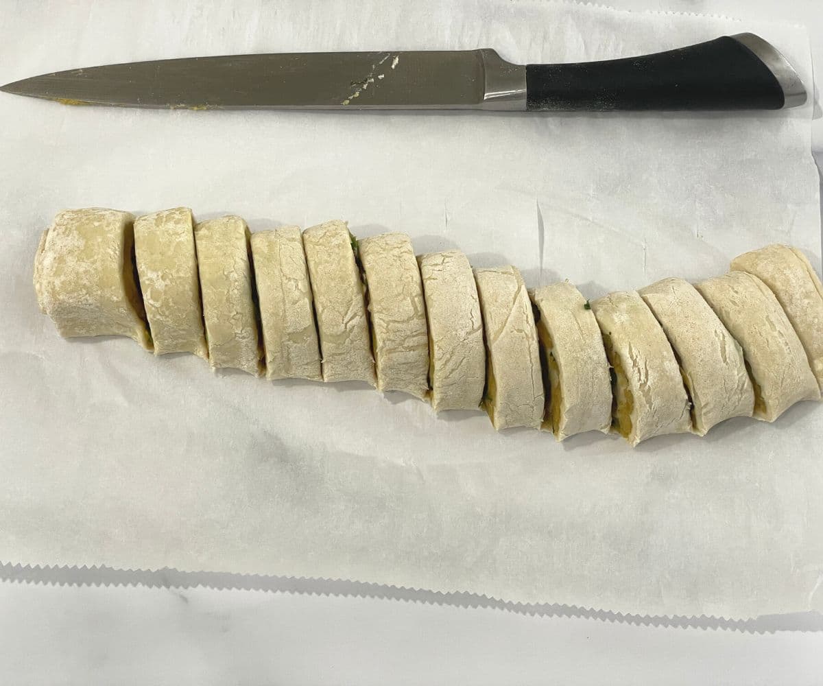 samosa pinwheels are sliced and placed on the dusted table.