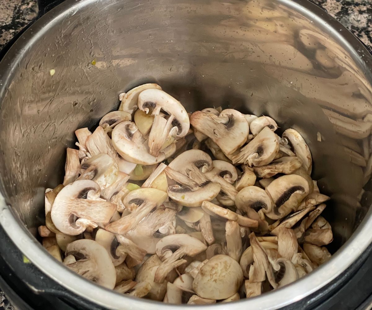 A pot is with mushrooms on saute mode.