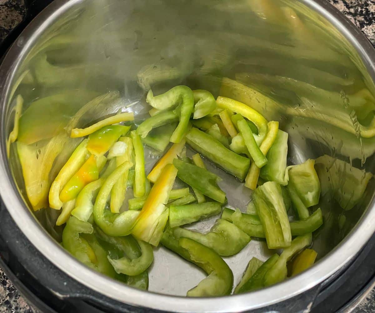 An instant pot is with bell peppers on saute mode.