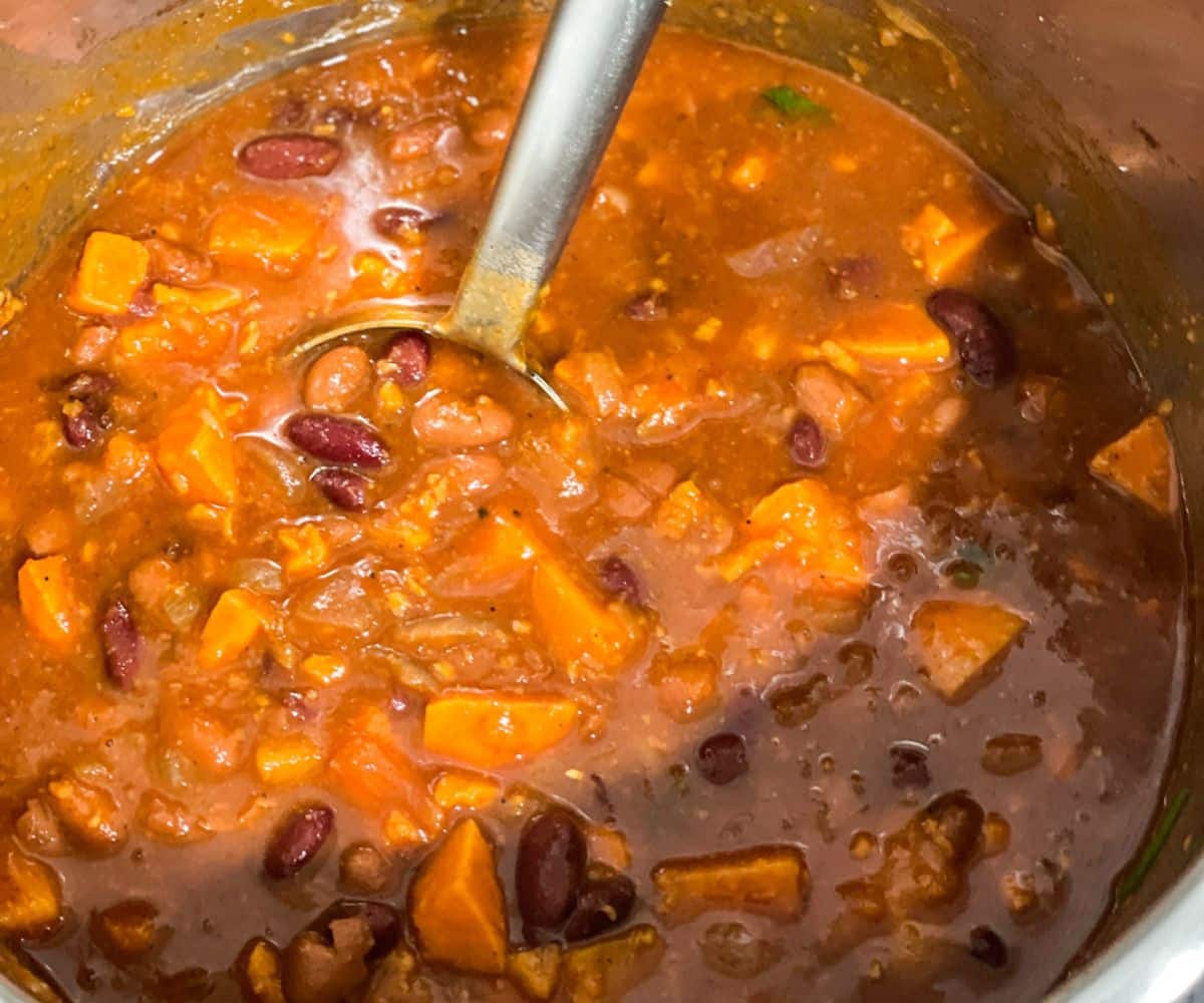 A pot of sweet potato chili is on the counter top.