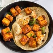 A plate of tandoori tofu tikka is with rotis.