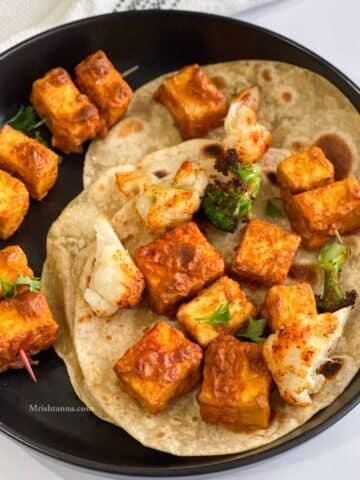 A plate of tandoori tofu tikka is with rotis.