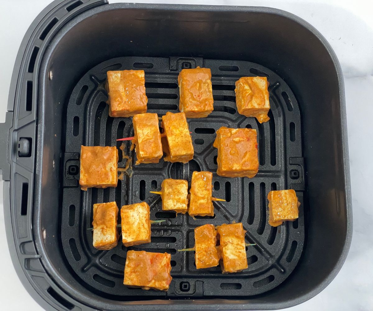 Air fryer basket is with tandoori tofu.