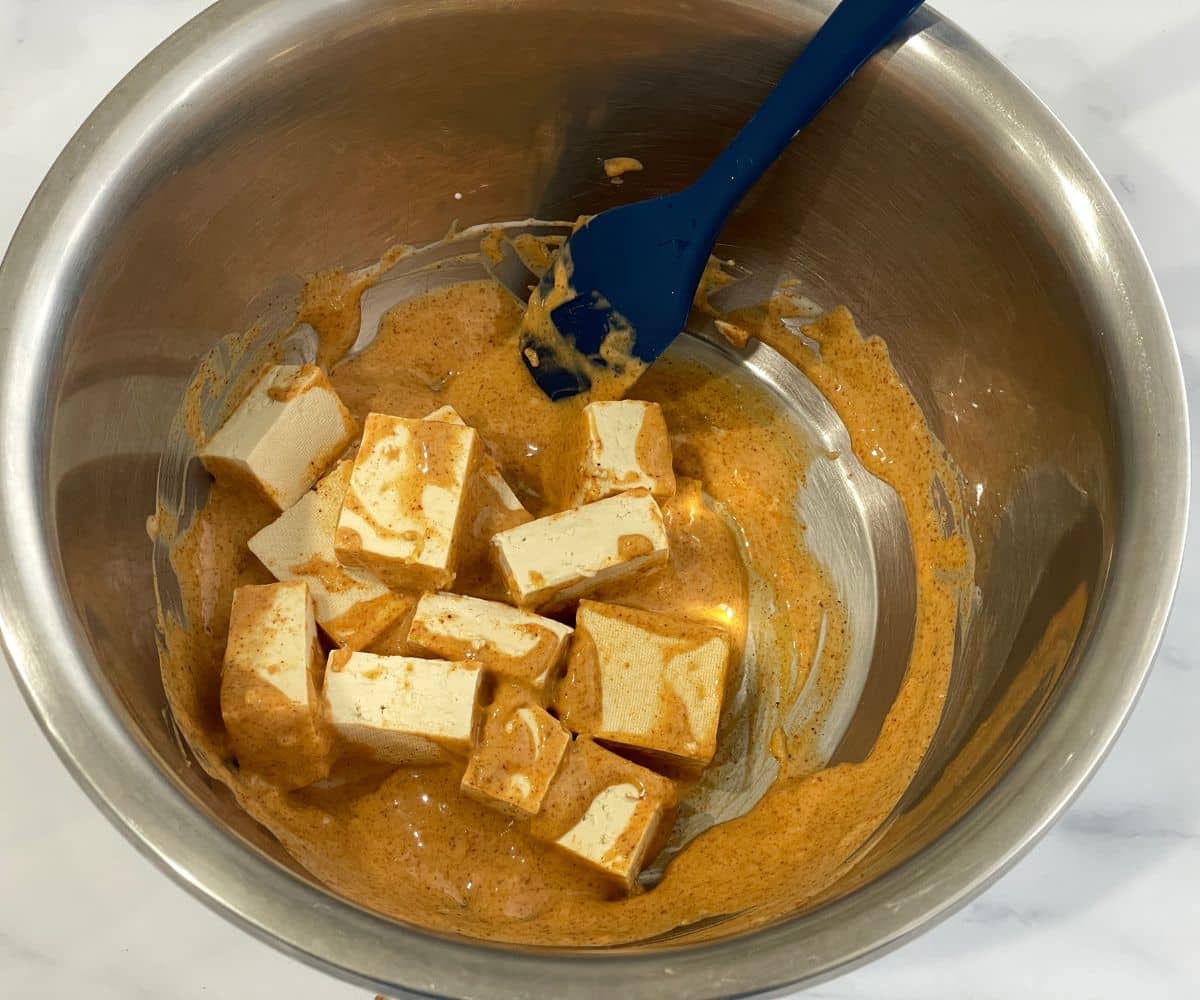 A bowl is with marinated tofu.