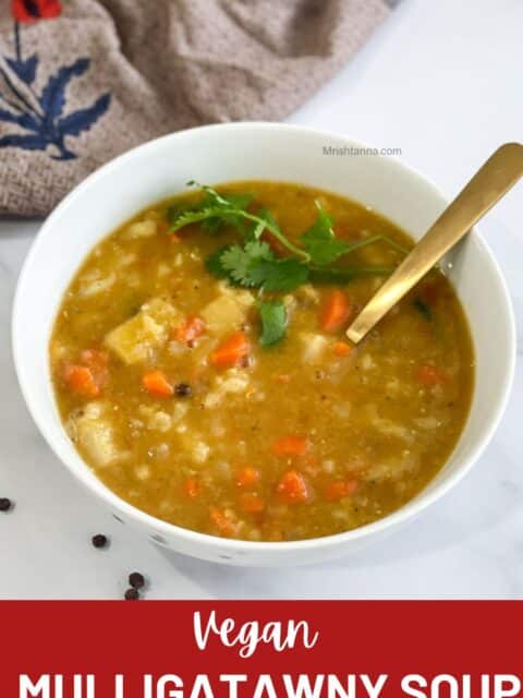 Vegan mulligatawny soup is poured into a white bowl with a spoon.