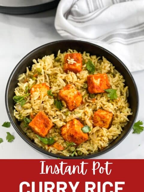 A bowl of curry rice is on the table topped with tofu.