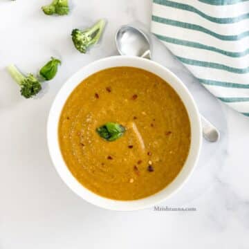 Head shot of a bowl with broccoli tomato soup.