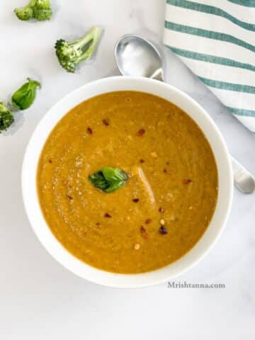 Head shot of a bowl with broccoli tomato soup.