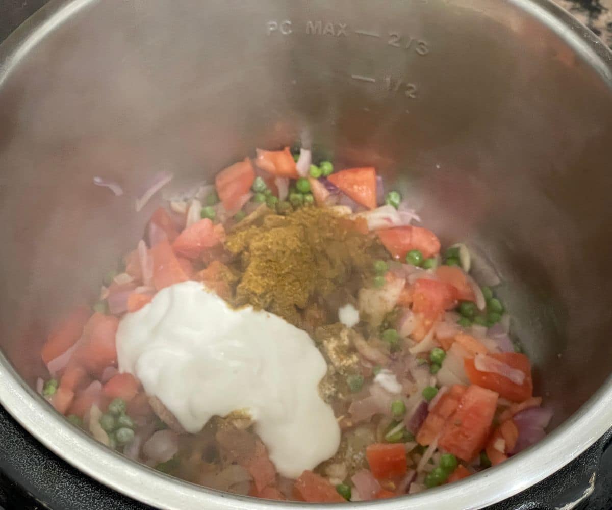 An instant pot is with spices, yogurt for curry rice.