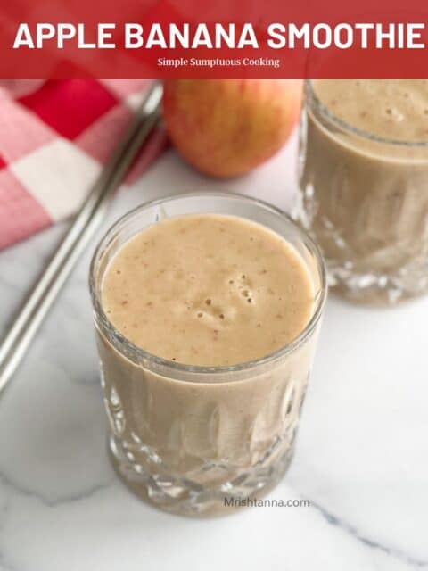 A glass is filled with apple banana smoothie on the table.