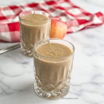 Close up of a glass with apple banana smoothie.