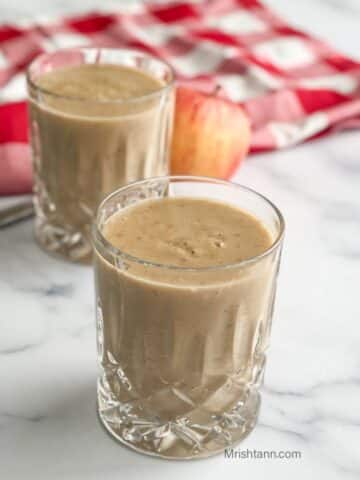 Close up of a glass with apple banana smoothie.