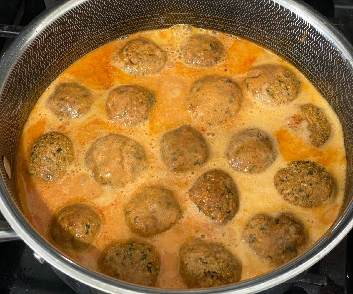 A pot is with falafel curry over the heat.