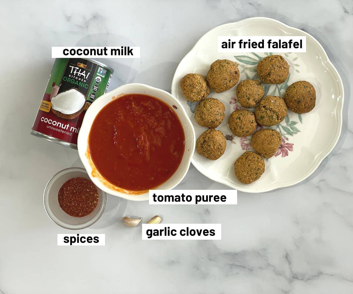 Table is filled with falafel curry ingredients.