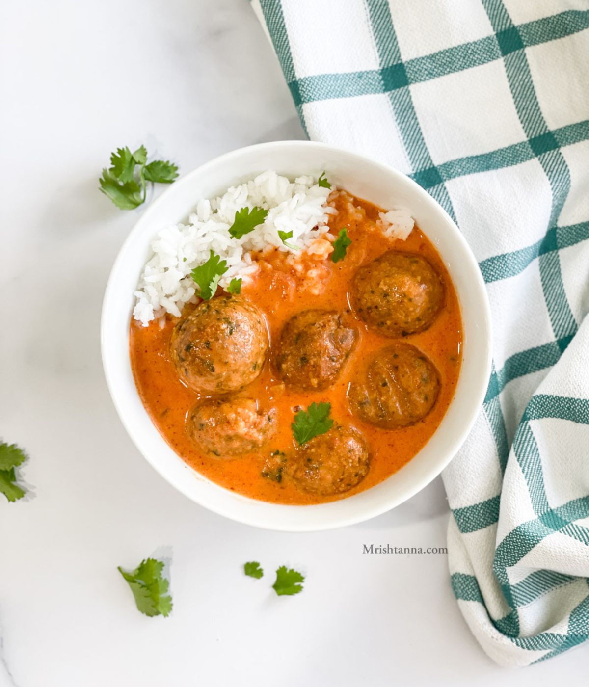 A bowl of falafel curry is on the table.