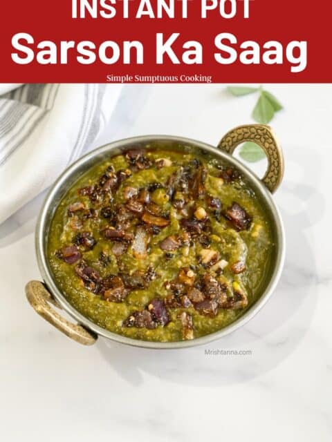 A copper bowl is with saag curry on the table.