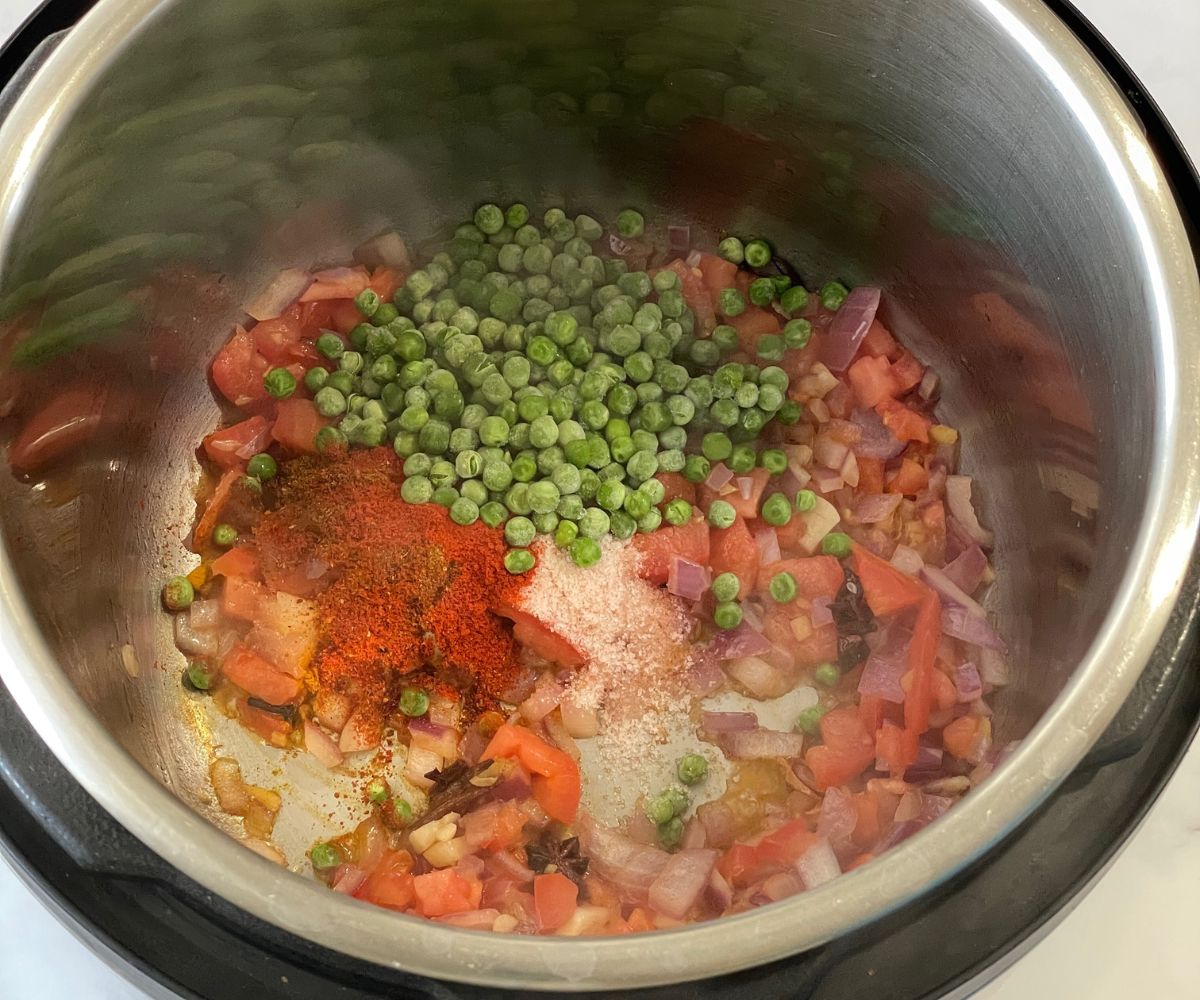 An instant pot is with methi rice spices and veggies.