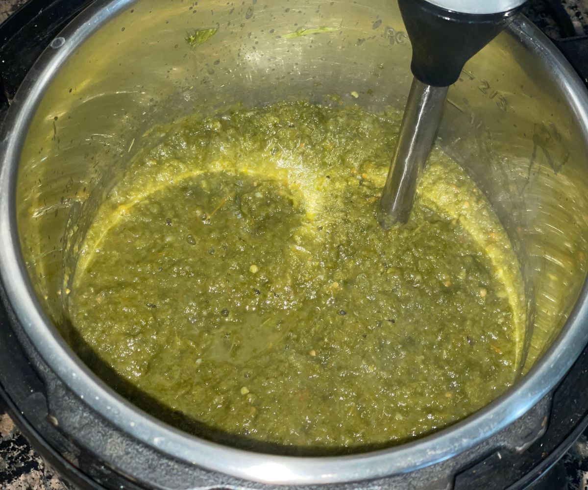 An instant pot is with blended sarson ka saag.
