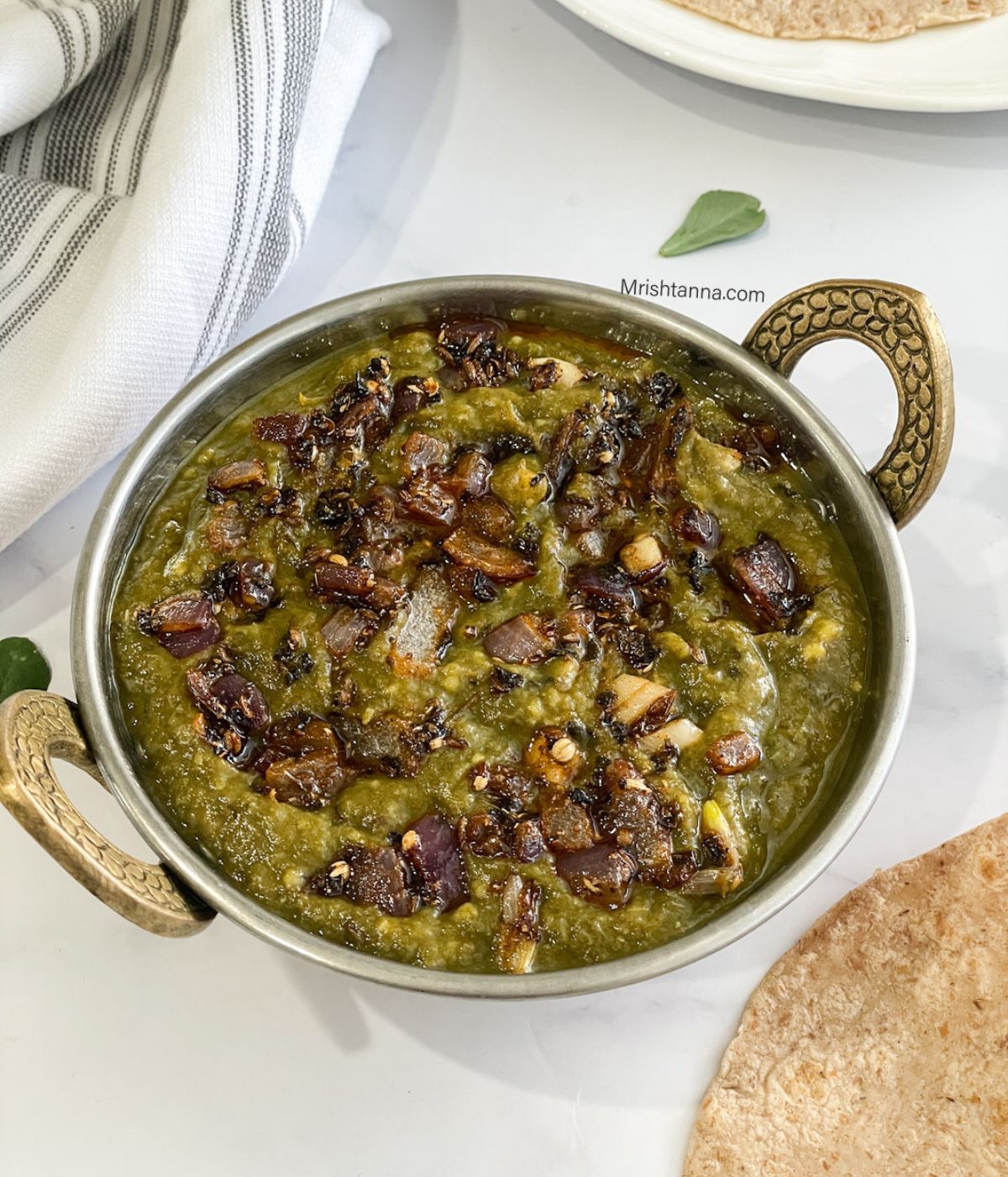 Close up of a bowl with mustard greens curry.