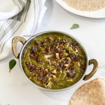 A bowl of instant pot sarson ka saag curry is on the table.