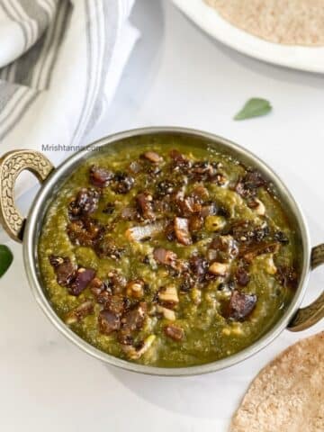 A bowl of instant pot sarson ka saag curry is on the table.