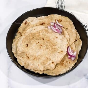A plate is with jowar rotis on the table.