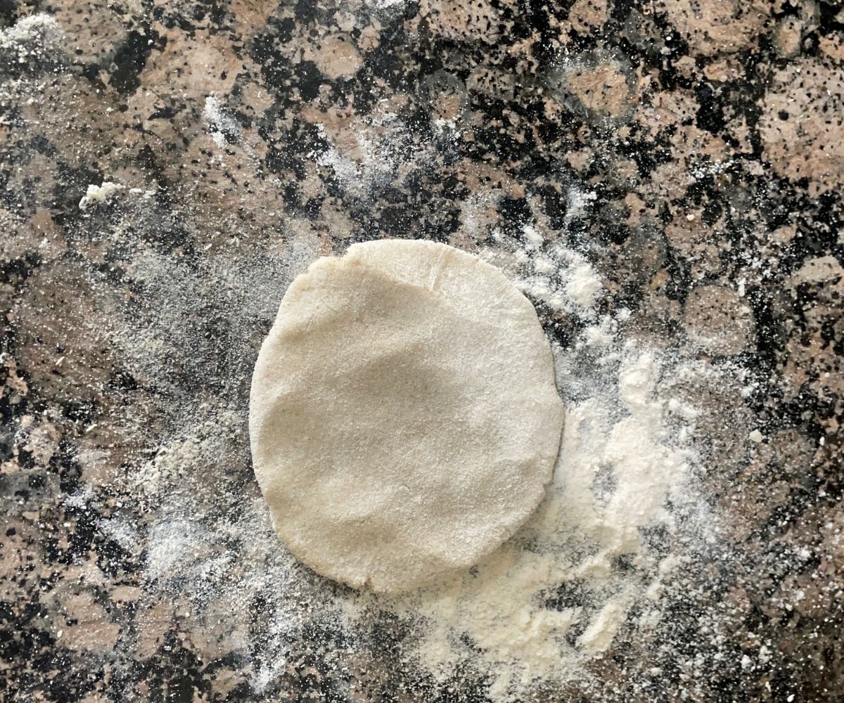 A flat surface is with small sorghum roti dough.