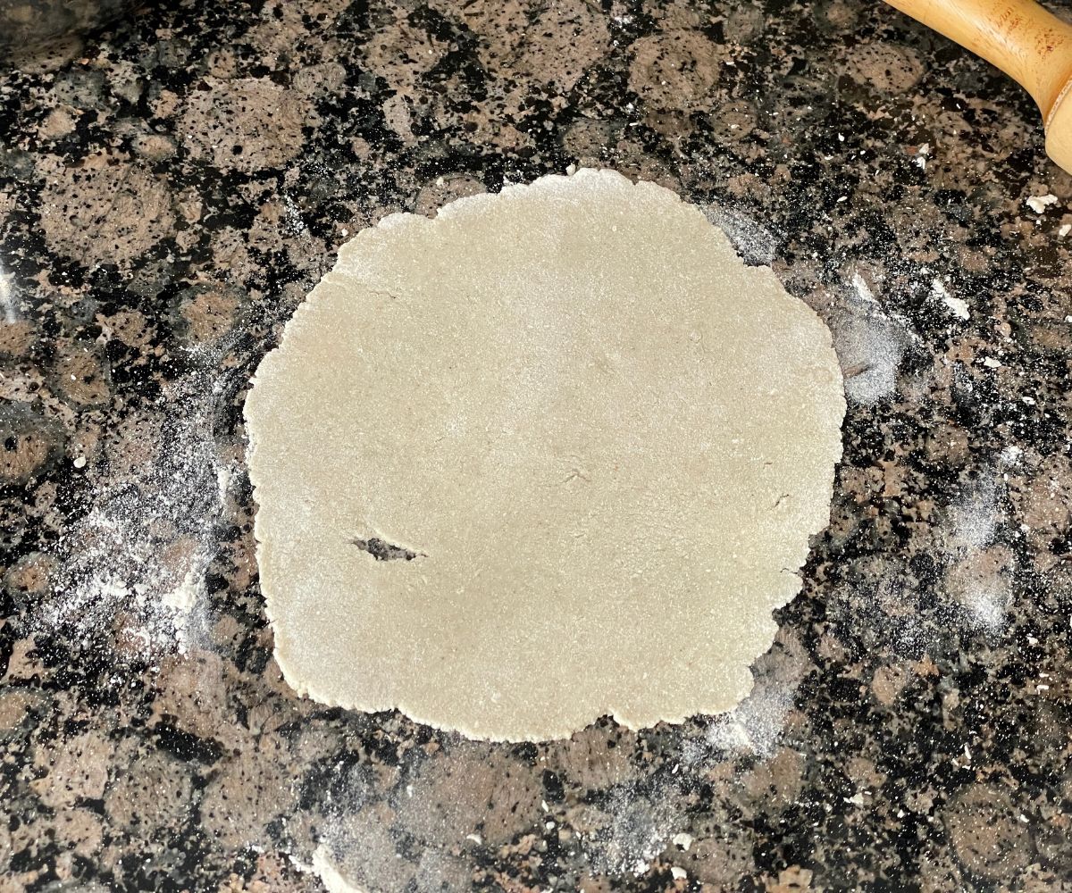 Flattened sorghum roti dough is on the surface.