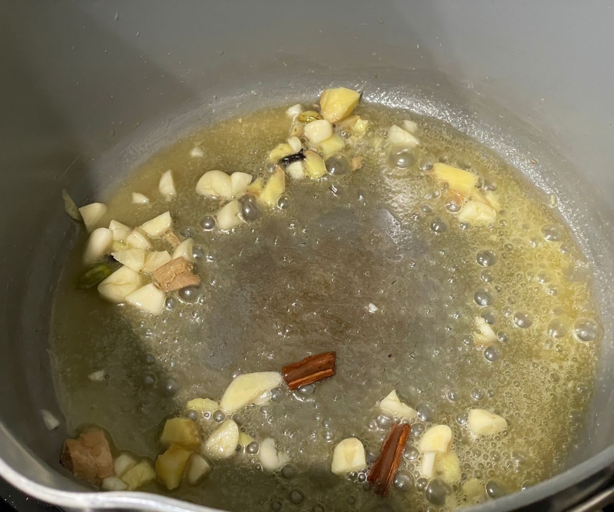 A pan is with vegan butter and whole spices over the heat.