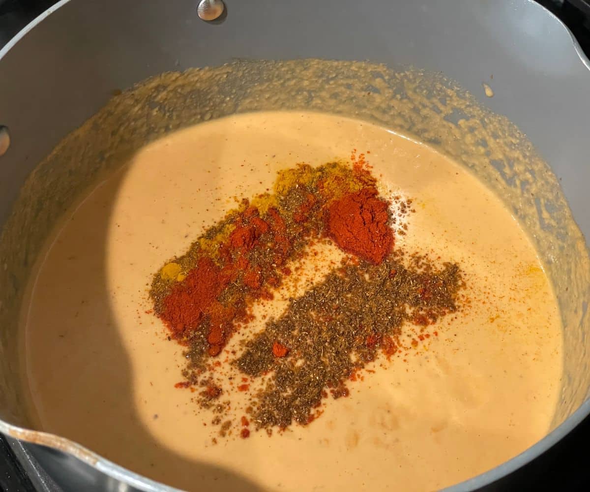 A pot is with tofu makhani curry over the heat.