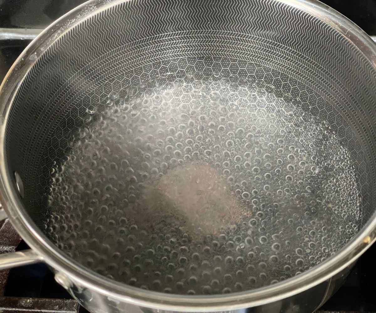 A pot is with boiling water over the stove top.