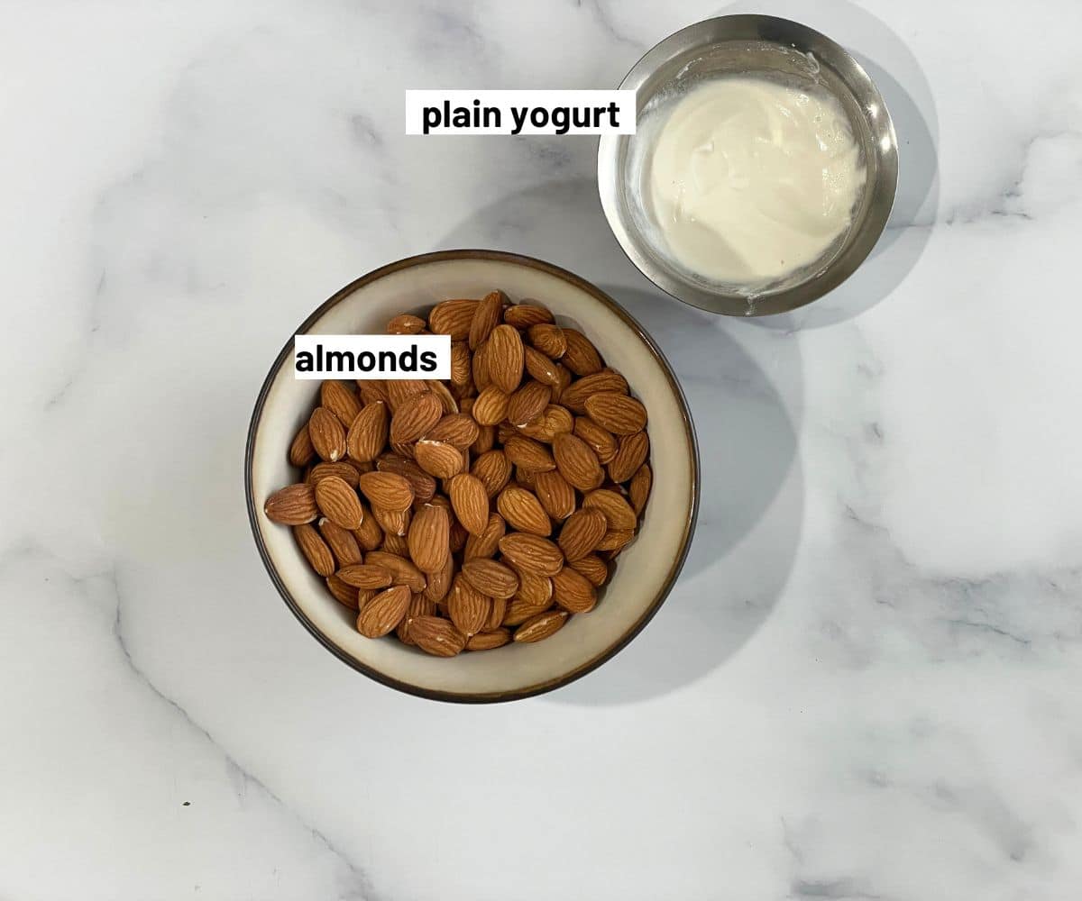 A bowl of almonds and yogurt is on the table.