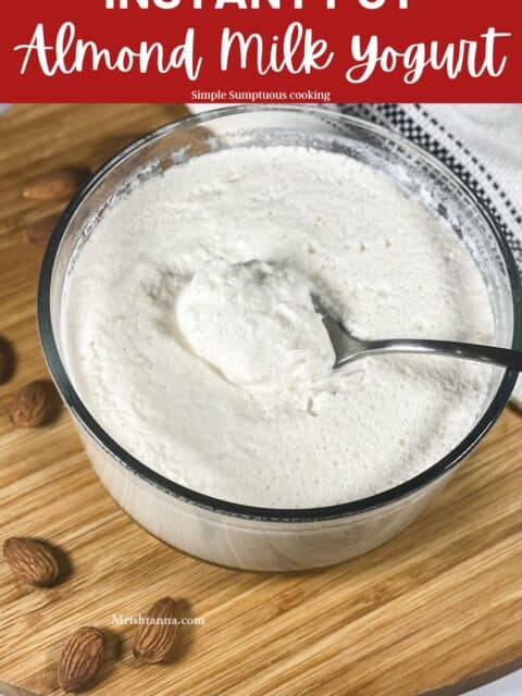 A glass bowl is filled with almond milk yogurt.