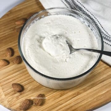 A spoon of almond milk yogurt is placed on the bowl.