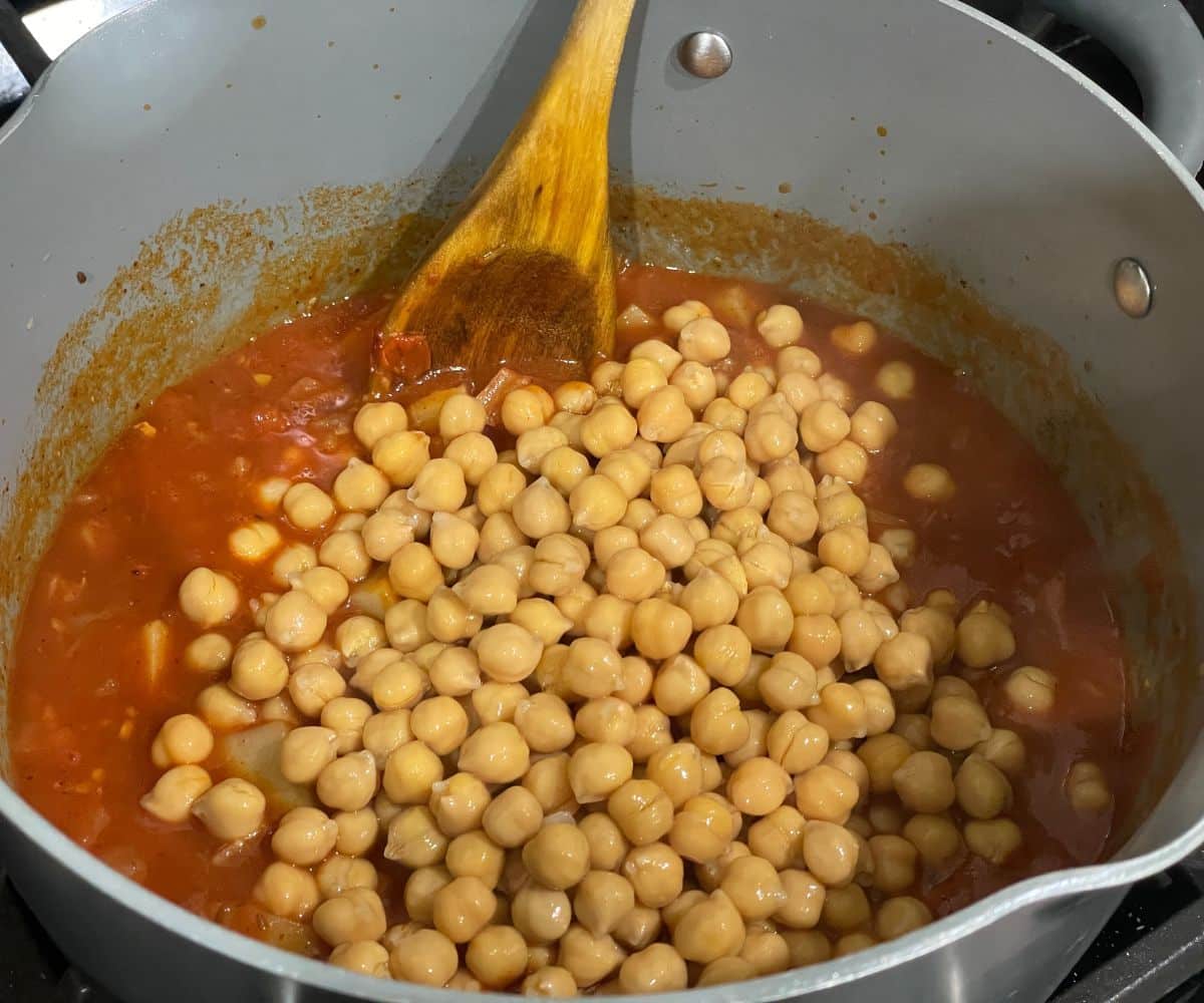 A pan is with aloo chana curry over the heat.
