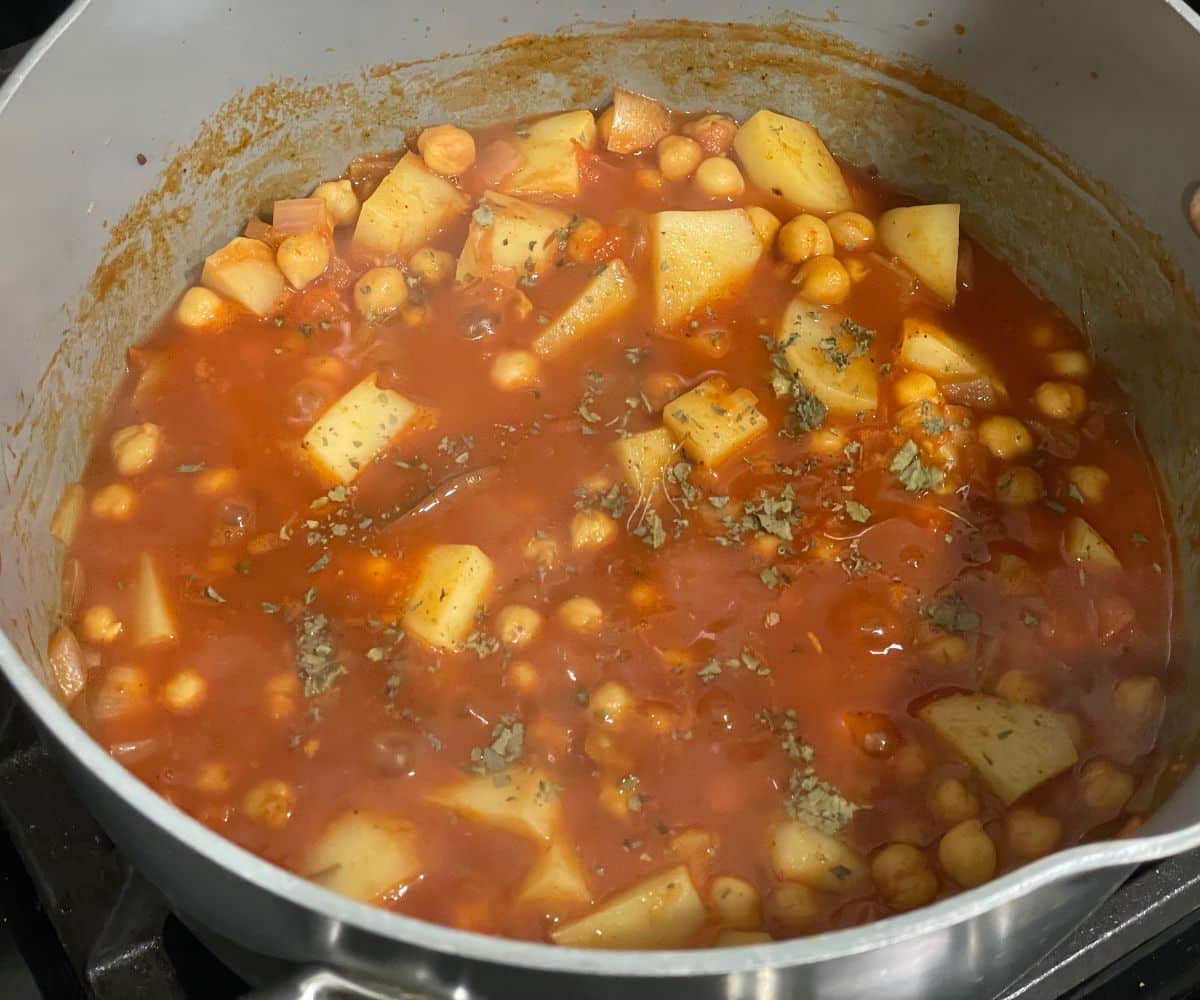 A pan of aloo chana curry is on the stove top.
