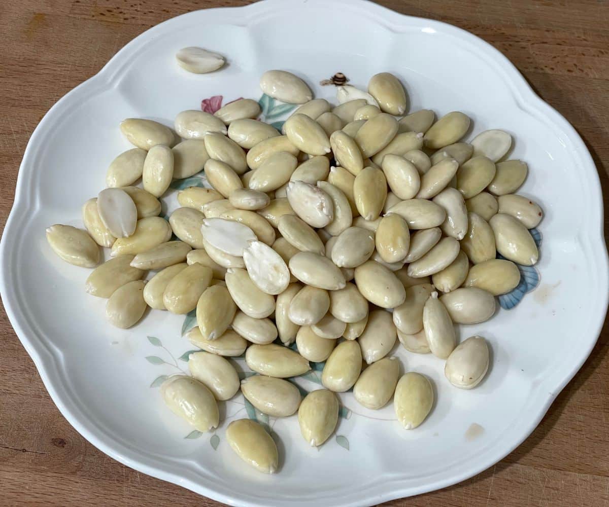A plate is with skinned almonds for yogurt.
