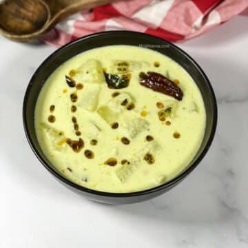 A bowl of mor kolambu is on the table.