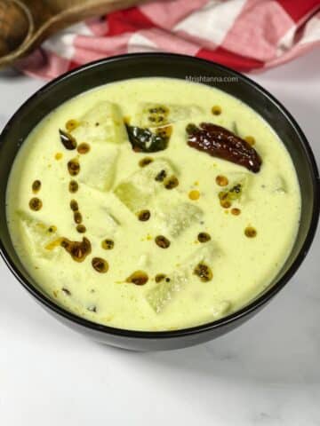 A bowl of mor kolambu is on the table.