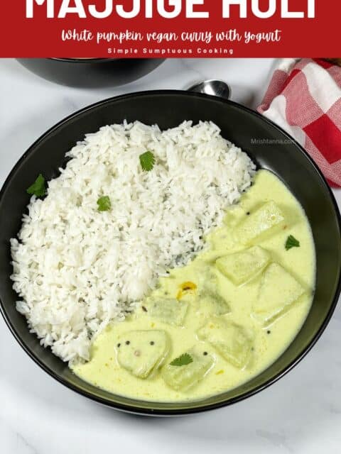 A bowl of yogurt curry is on the table along with rice.