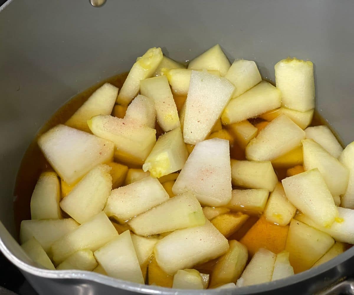 A pan is with ash gourd  and turmeric over the heat.