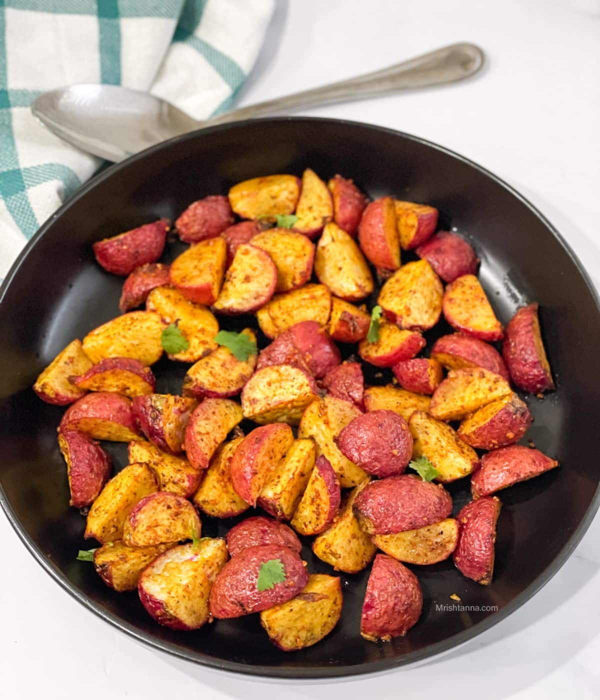 A plate is with roasted radishes on the table.