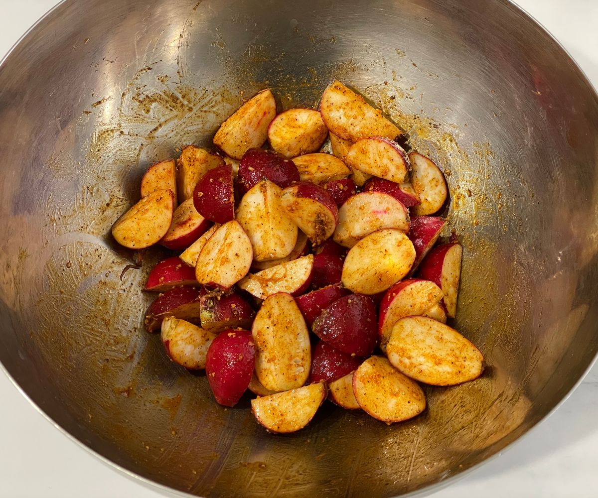 A bowl is with spice coated radishes.