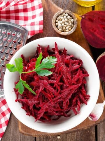A bowl of grated beets and diced beets are on the table.