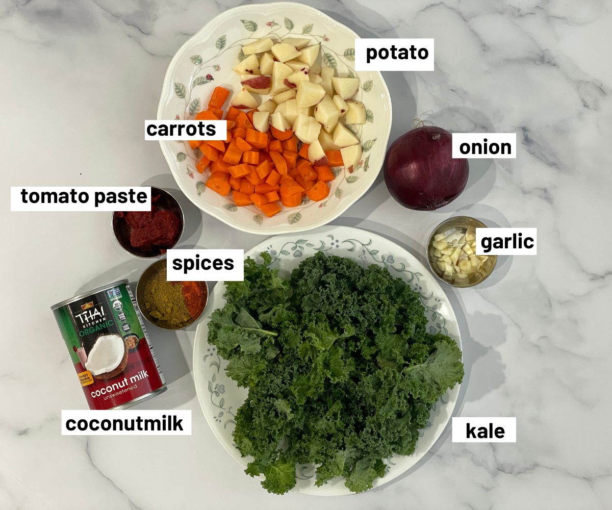 A table is covered with kale curry ingredients.